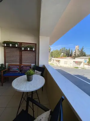 a small table on the balcony of a house at Kition Cozy Residence in Larnaka