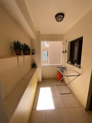 a room with a hallway with a table and a window at Kition Cozy Residence in Larnaka