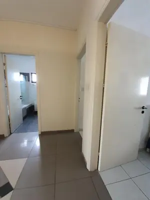 a hallway with white walls and white floors and doors at Bright and Cozy 2-Bedroom Apartment in Strovolos in Strovolos