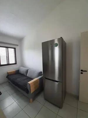 a room with a refrigerator and a couch in it at Bright and Cozy 2-Bedroom Apartment in Strovolos in Strovolos