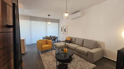 a living room with a couch and a table at STAY Larnaca Pearl Apartment in Larnaka