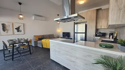 a kitchen with a counter and a table in a room at STAY Larnaca Pearl Apartment in Larnaka