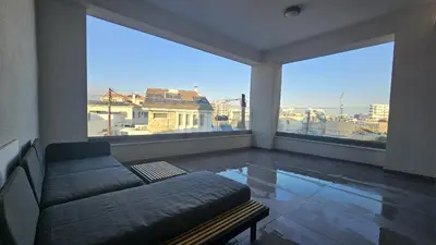 a living room with a couch and two large windows at STAY Larnaca Pearl Apartment in Larnaka