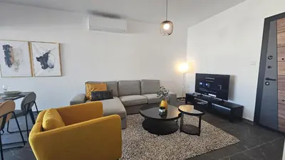 a living room with a couch and a table at STAY Larnaca Pearl Apartment in Larnaka