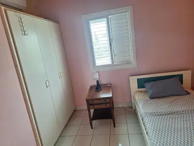 a bedroom with a bed and a dresser and a window at Big house near sea, shared swimming pool in Voroklini