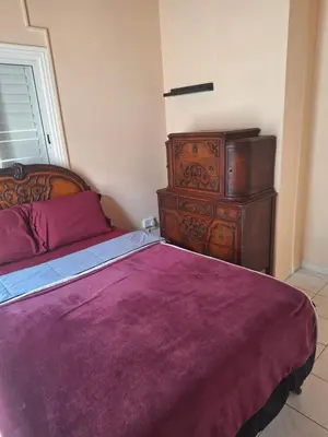 a bedroom with a purple bed and a dresser at Big house near sea, shared swimming pool in Voroklini