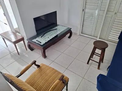 a living room with a tv and a chair at Big house near sea, shared swimming pool in Voroklini