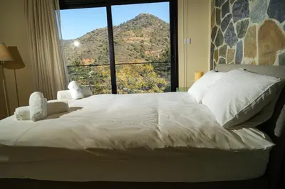 a bedroom with a large bed with a large window at Luxury 5-Bedroom Chalet Kalopanayiotis in Kalopanayiotis