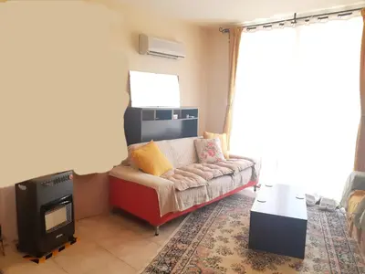 a living room with a couch and a tv at Cozy apartment in Larnaka