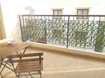 a balcony with a bench and a table and a fence at Cozy apartment in Larnaka