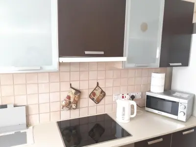 a kitchen with white cabinets and a counter top at Cozy apartment in Larnaka
