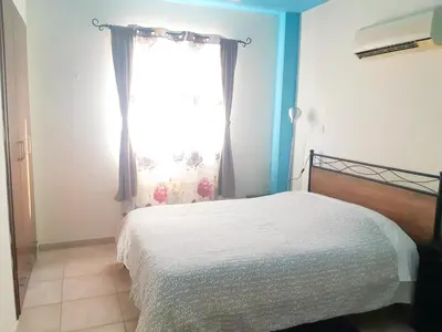 a bedroom with a bed and a window at Cozy apartment in Larnaka