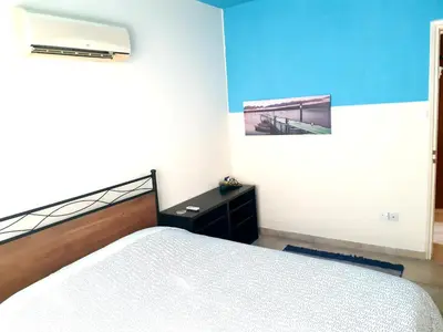 a bedroom with a bed and a painting on the wall at Cozy apartment in Larnaka