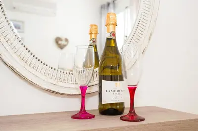 two bottles of wine and two glasses on a table at Jules Apartment in Paralimni