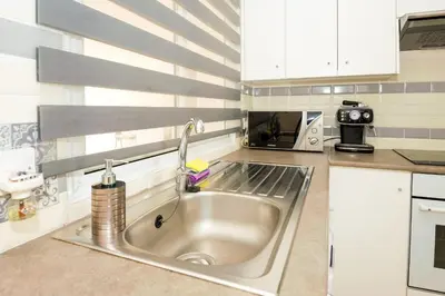 a kitchen with a sink and a microwave at Jules Apartment in Paralimni