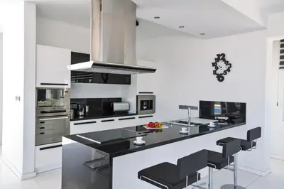 a kitchen with a black counter and black stools at Villa Marilia in Protaras