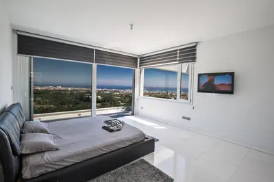 a bedroom with a bed and a large window at Villa Marilia in Protaras