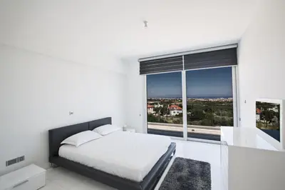 a bedroom with a bed and a large window at Villa Marilia in Protaras