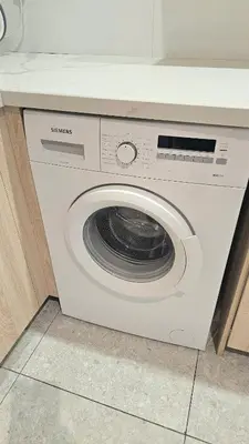 a white washing machine sitting in a kitchen at Touch of class Molos Limassol in Limassol