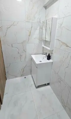 a white bathroom with a sink and a mirror at Antionette Studio Apartment in Limassol