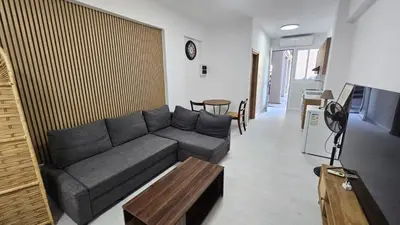 a living room with a gray couch and a table at Antionette Studio Apartment in Limassol