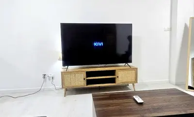 a flat screen tv sitting on a stand in a living room at Antionette Studio Apartment in Limassol