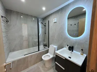 a bathroom with a sink and a toilet and a mirror at THE A-LINE SEAVIEW MALAMA APARTMENT with pool, tennis court & gym in Paralimni
