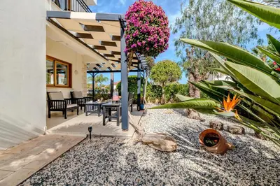an outdoor patio with a table and flowers at Tranquility Villa in Ayia Napa