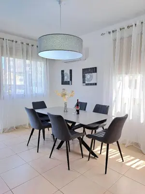 a dining room with a table and chairs at SERENITY PEARL VILLA at the sea in Protaras