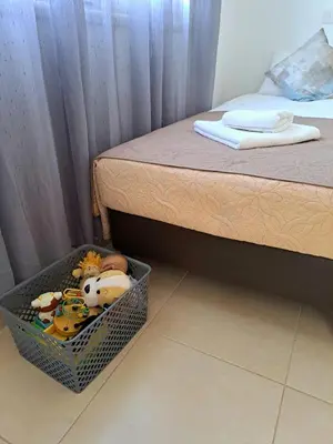 a basket full of toys sitting next to a bed at SERENITY PEARL VILLA at the sea in Protaras