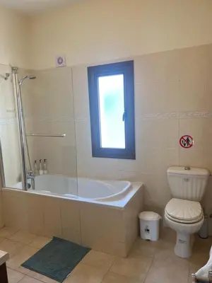 a bathroom with a tub and a toilet and a window at Tranquil paradise in Aradhippou