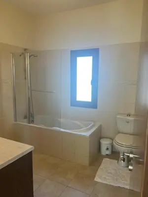 a bathroom with a tub and a toilet and a window at Tranquil paradise in Larnaka