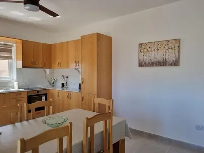 a kitchen with a table and chairs and a table and a table and a kitchen at Kafkalia Sea Breeze in Larnaka