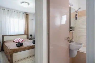 a small bathroom with a bed and a sink at Carisa flat, 2 bedrooms in Larnaka