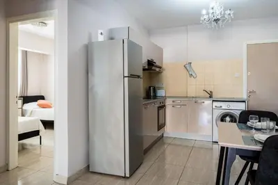 a kitchen with a stainless steel refrigerator and a table at Carisa flat, 2 bedrooms in Larnaka