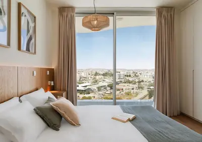a bedroom with a bed and a large window at Suite 1003 at Althea Residence in Larnaka