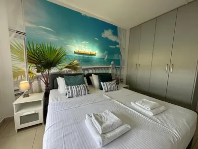 a bedroom with a large bed with a painting on the wall at Protaras Sunset Bay in Protaras