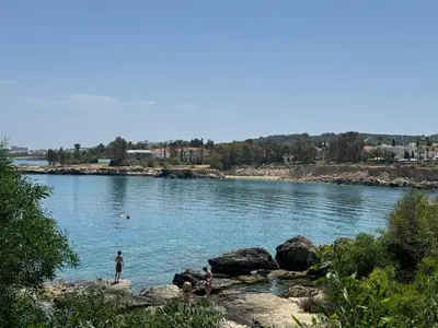 a group of people standing on rocks in a river at Protaras Sunset Bay in Protaras