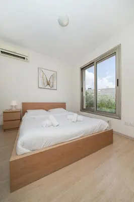a bedroom with a large bed and a window at Central Luxurious 2 bedroom flat in Strovolos