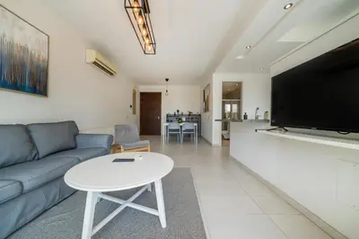 a living room with a couch and a table and a tv at Central Luxurious 2 bedroom flat in Strovolos