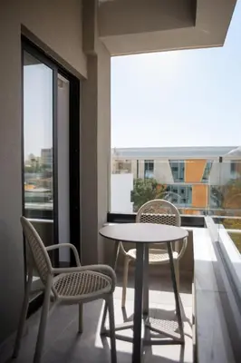 a table and chairs on a balcony with a window at Le Bouquet Luxury Suites Ltd in Nicosia