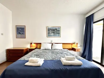 a bedroom with a blue bed with two white towels at STAY NISSI Chrysland Studios in Ayia Napa