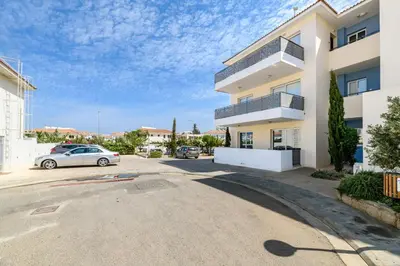 a building with a car parked in a parking lot at Mythical Sands Apartment BA09 in Protaras
