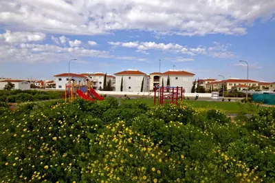 a playground with a red slide in a field of flowers at Mythical Sands Apartment BA09 in Protaras