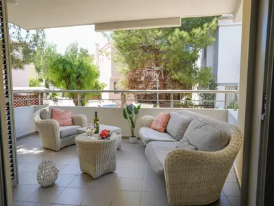 a patio with wicker chairs and a couch on a balcony at Mediterranean Escape - Coastal 2-Bedroom Apartment Limassol in Limassol