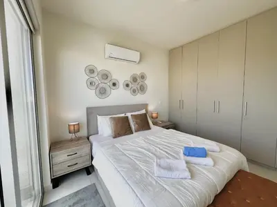 a bedroom with a large white bed with towels on it at STAY Mythical Blue Apartment in Protaras