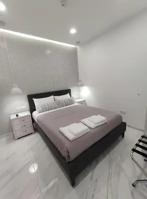 a bedroom with a large bed with two towels on it at Ermioni Apartments in Limassol