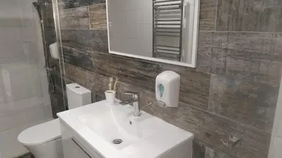 a bathroom with a sink and a toilet and a mirror at Ermioni Apartments in Limassol