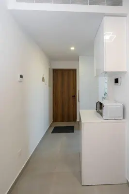 a kitchen with white walls and a wooden door at Seaview Suite49 steps to Mackenzie Beach Larnaca in Larnaka