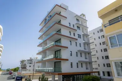 a tall white building with balconies on a street at Seaview Suite49 steps to Mackenzie Beach Larnaca in Larnaka